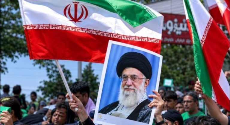 Iranian supporters hold flags and portrait during US-Iran nuclear deal negotiations rally